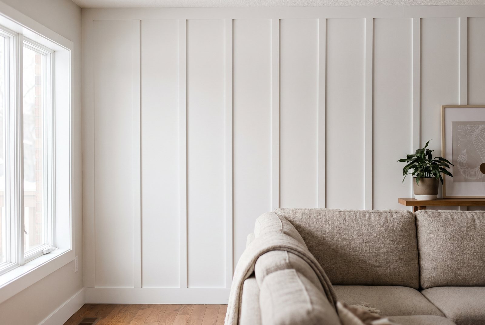 Finished white painted board-and-batten accent wall in a living room