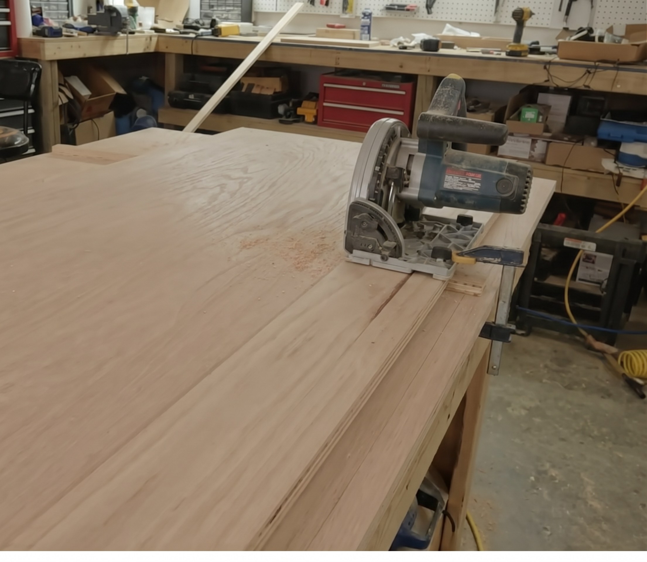 DIY plywood track saw jig on sawhorses, 8 feet long, with a circular saw resting on top